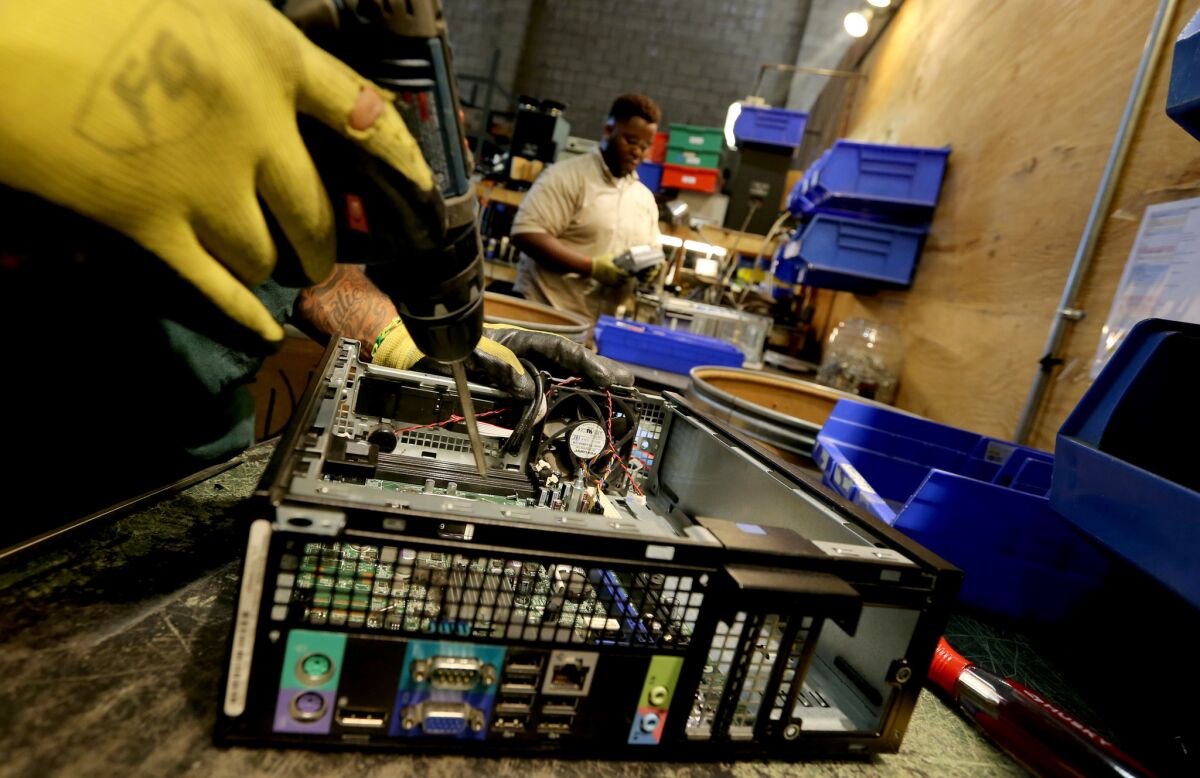 Workers dismantle old electronic equipment at Isidore Electronics Recycling, which Homeboy Industries has acquired and will rename Homeboy Recycling.