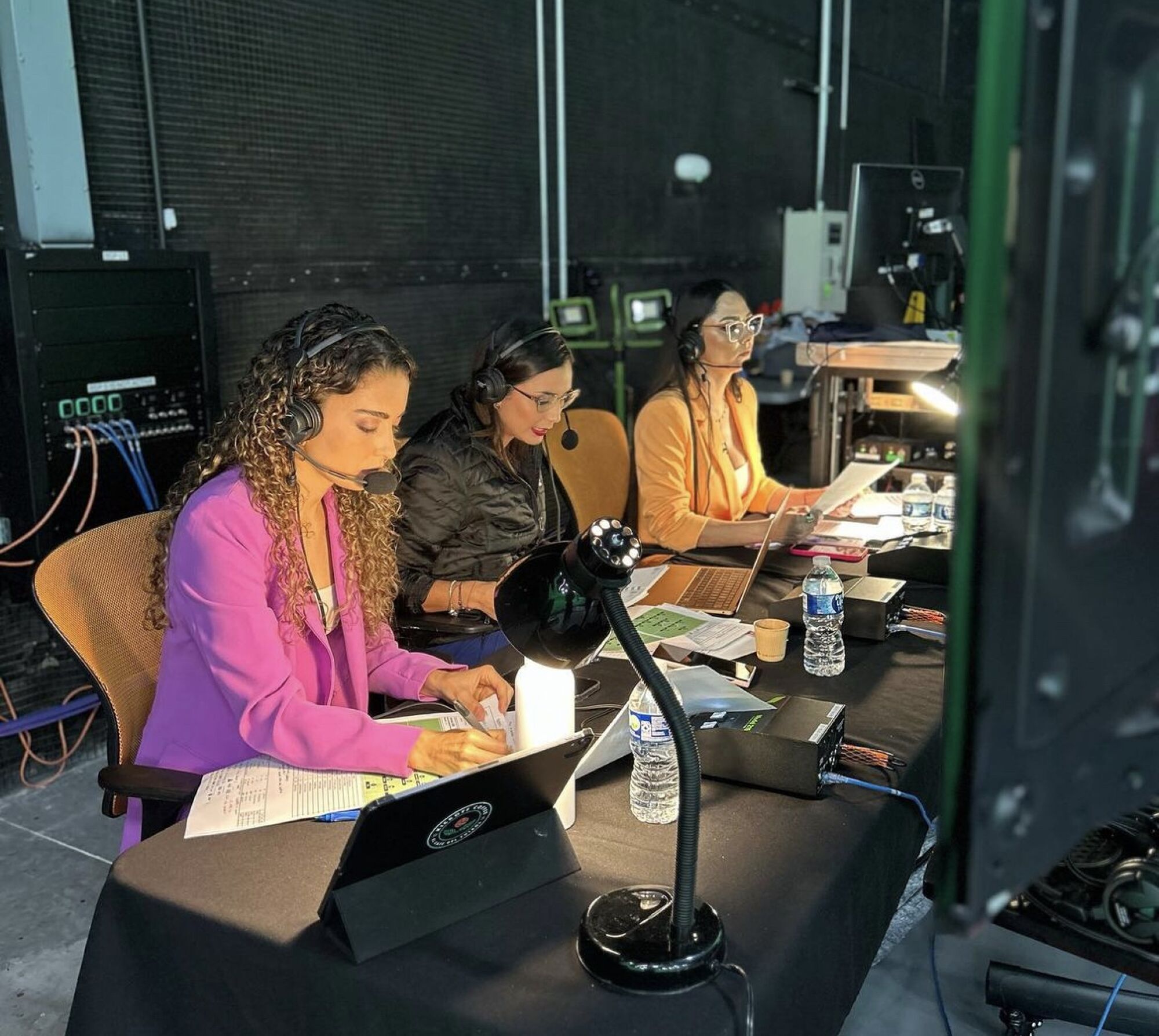 Three women in a TV booth calling a soccer match