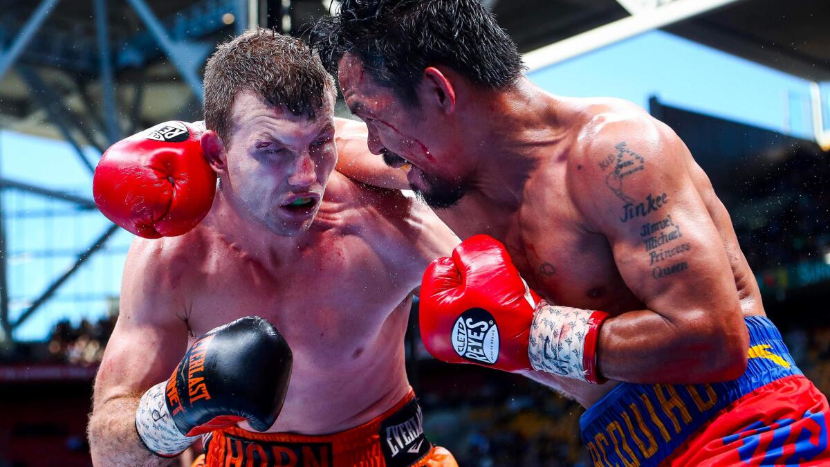 Jeff Horn, left, and Manny Pacquiao trade punches during their WBO welterweight title fight on Sunday afternoon in Brisbane, Australia.