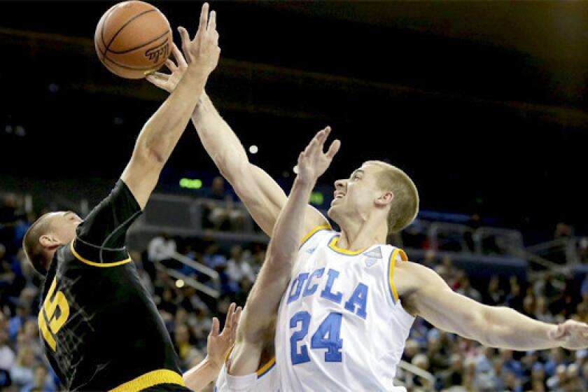 Travis Wear blocks a shot by Arizona State's Egor Koulechov during UCLA's 87-72 victory Sunday over the Sun Devils.