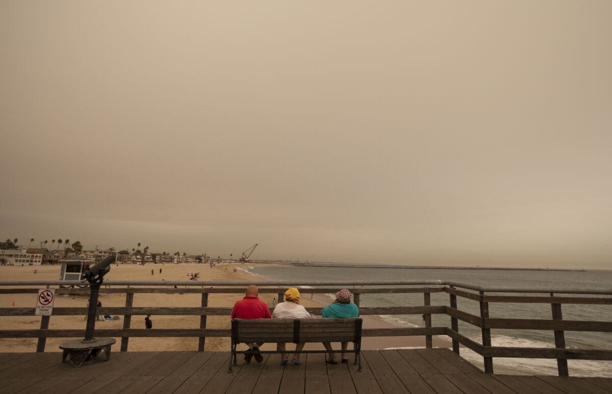 Ash and smoke were in the air over Seal Beach, Calif., on Thursday.