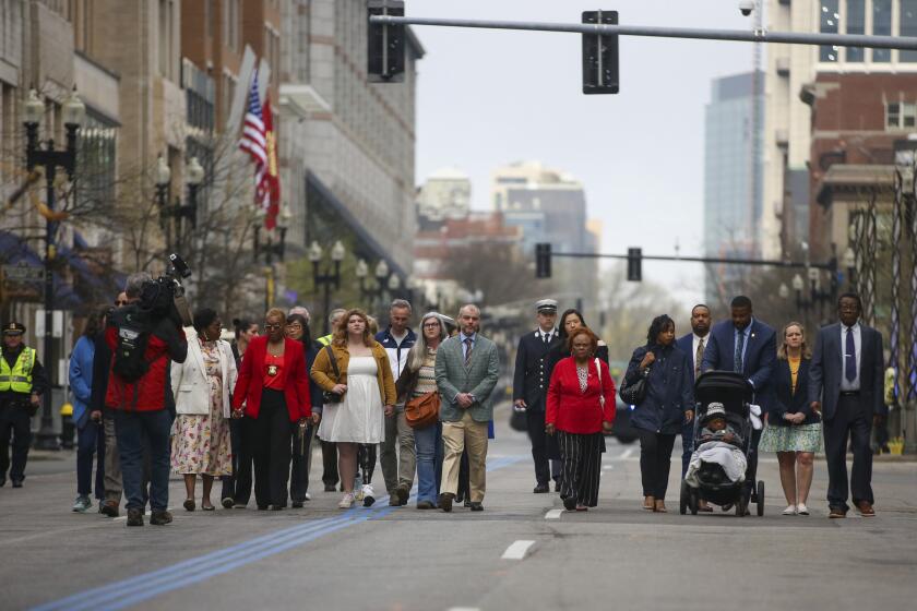 Participants of a gathering for victims of the 2013 Boston Marathon bombing process between memorials on Boylston Street, Saturday April 15, 2023, in Boston. (AP Photo/Reba Saldanha)