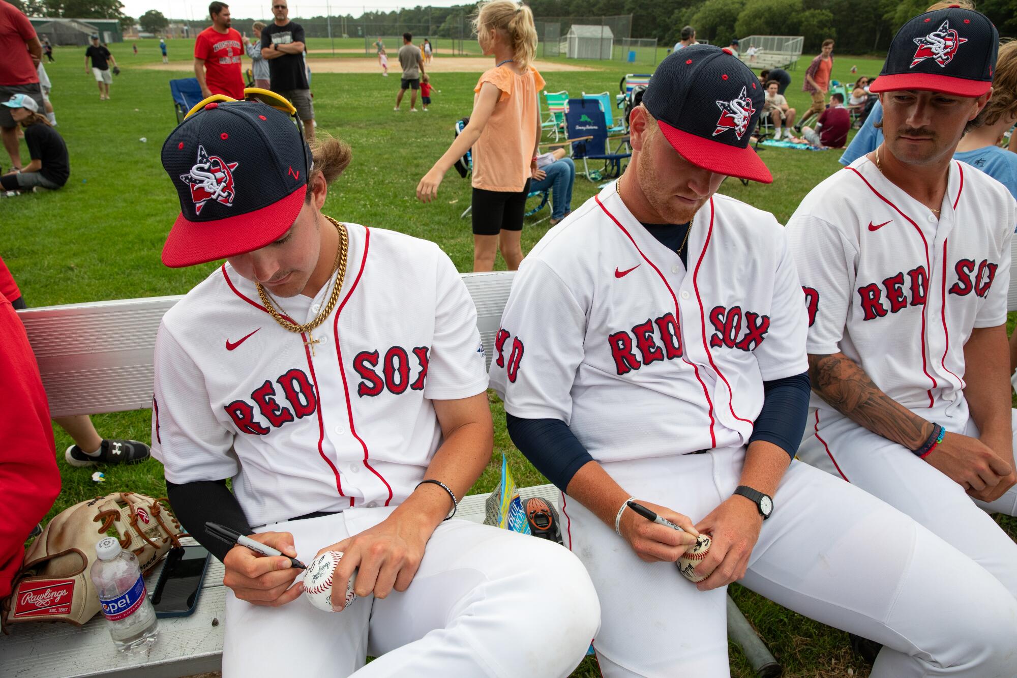 Red Sox players sign autographs after the game against Orleans. 