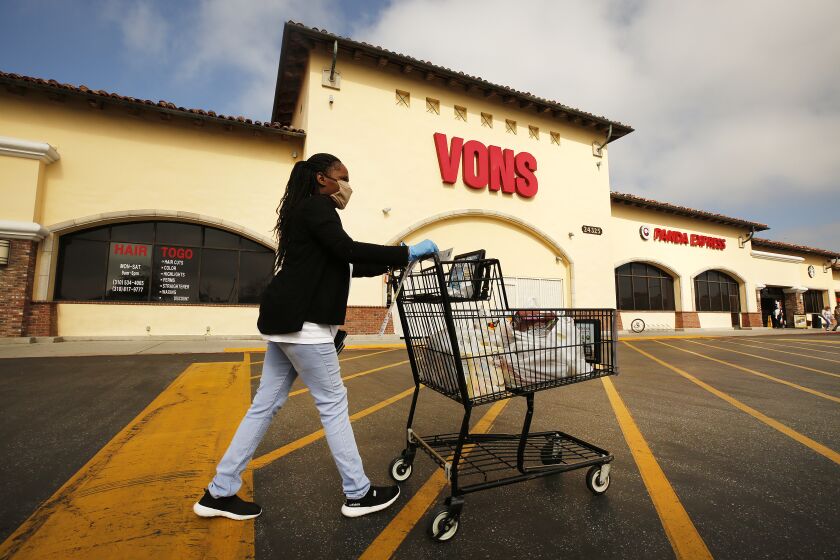 TORRANCE, CA - APRIL 27: Vons shopper Marcena Mitchell finishes her shopping in the morning at the Vons located at 24325 Crenshaw Blvd in Torrance. Doors to the store opened at 6 a.m. for seniors and at-risk shoppers due to the Coronavirus and at 7 a.m. for regular customers. Most of the team arrives at 5 a.m. to stock the shelves with product, sanitize the location for staff and shoppers, and picker/shoppers begin to collect items for .com home delivery shoppers. Vendors arriving throughout the morning must read a checklist of warnings, sign in and they must wear face covering. Vons on Monday, April 27, 2020 in Torrance, CA. (Al Seib / Los Angeles Times)