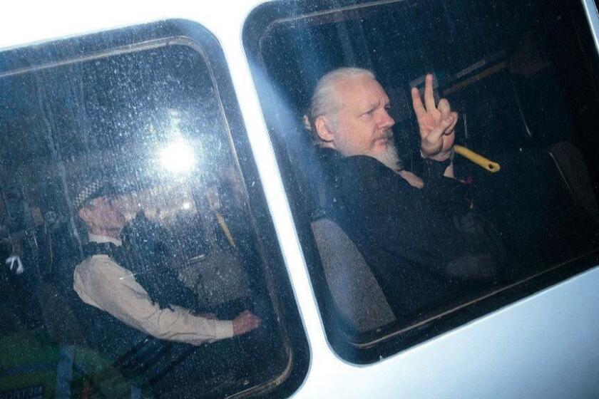 Julian Assange gestures to the media from a police vehicle on his arrival at Westminster Magistrates court on April 11, 2019 in London. (Jack Taylor/Getty Images/TNS) **FOR USE WITH THIS STORY ONLY** ** OUTS - ELSENT, FPG, TCN - OUTS **