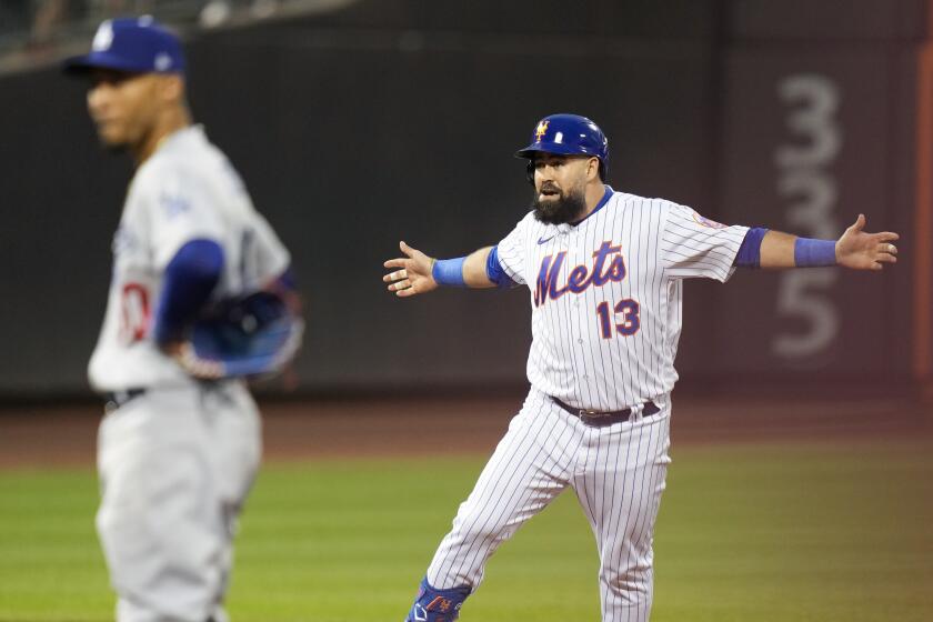 New York Mets' Luis Guillorme, right, reacts after hitting a walk-off RBI double in the 10th inning against the Dodgers.