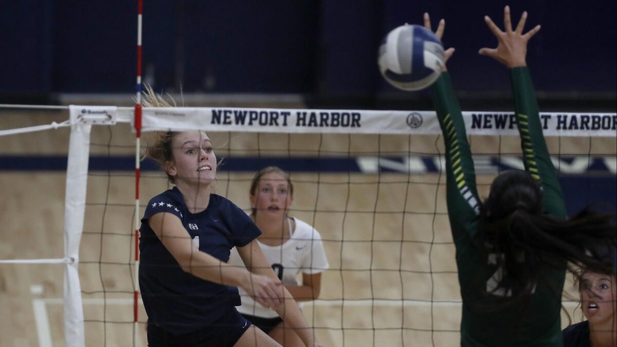 Newport Harbor High's Kendall Bagby, left, spikes the ball against Edison during the second set of a Sunset Conference crossover match on Thursday.