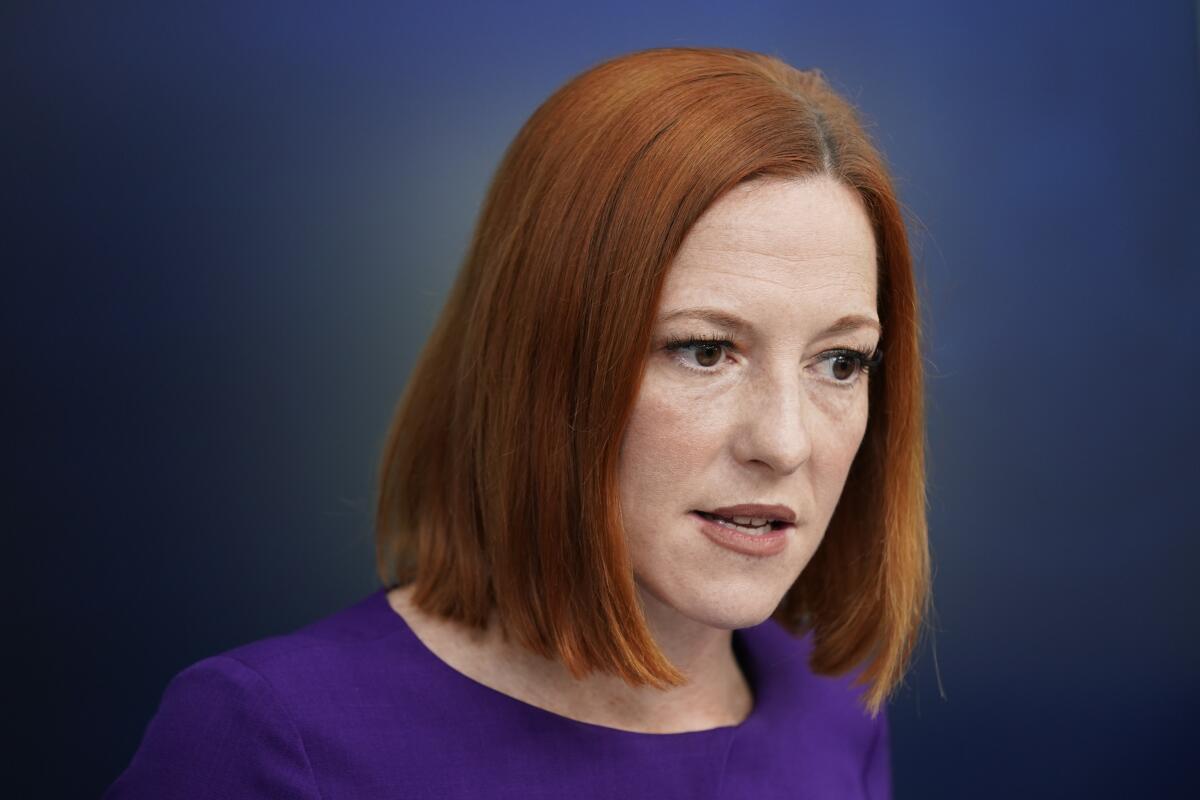 A woman with red hair and a blue blouse looks down 