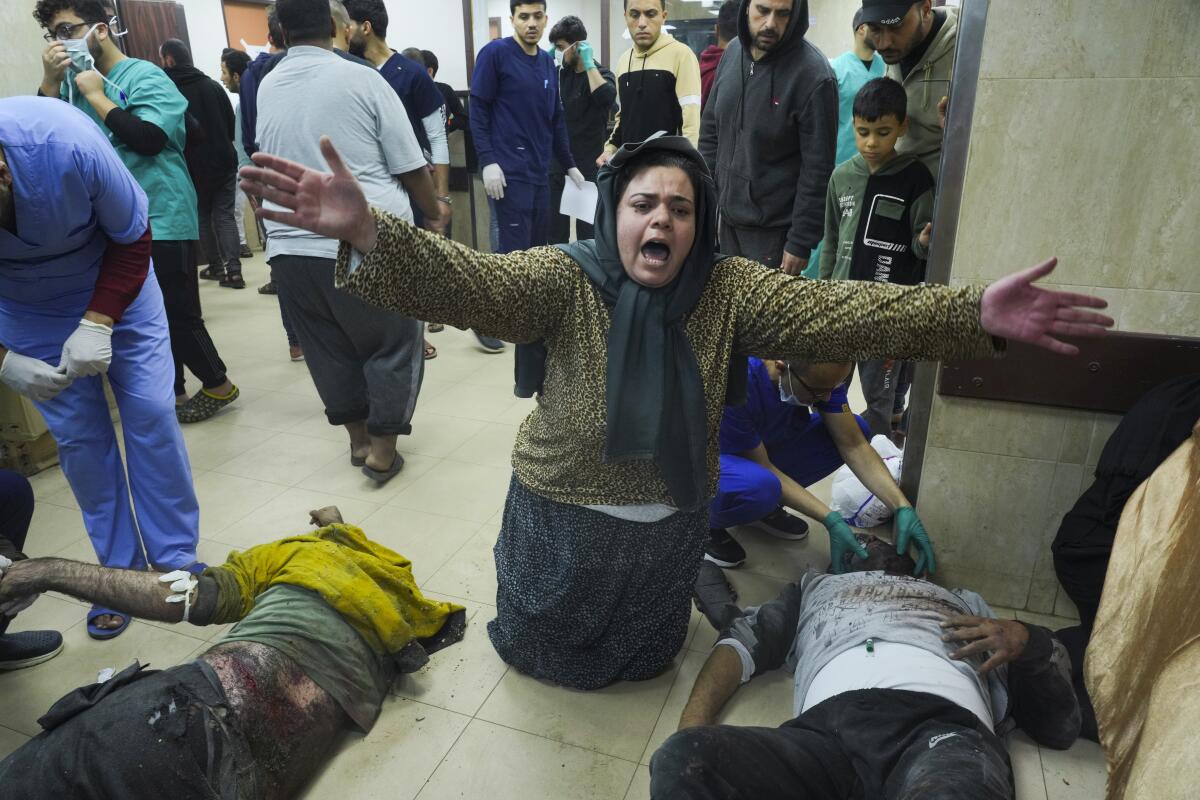 A woman gestures over wounded people at a hospital