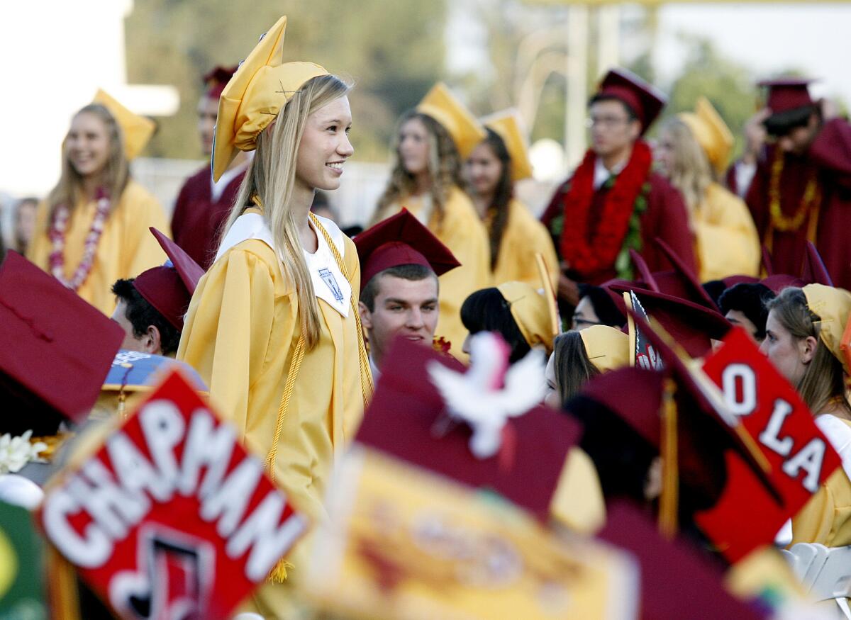 Graduate Robin Miketta smiles, looking into the audience, after receiving her diploma cover at La Canada High School's graduation ceremony.