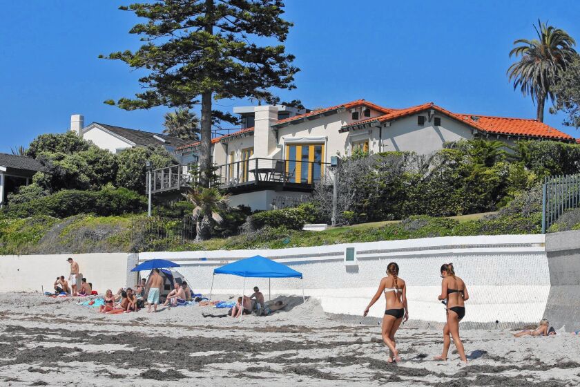 Beachgoers enjoy a sunny day in front of Mitt Romney’s La Jolla home in 2012.
