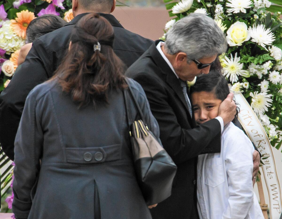 Robert Velasco, father of Yvette Velasco, consoles a family member during his daughter's funeral service at Forest Lawn - Covina Hills.