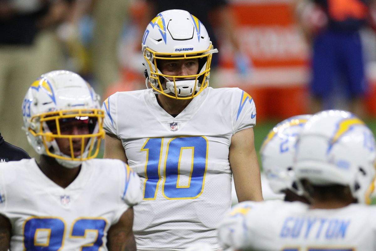 Chargers quarterback Justin Herbert (10) walks off the field behind teammates.