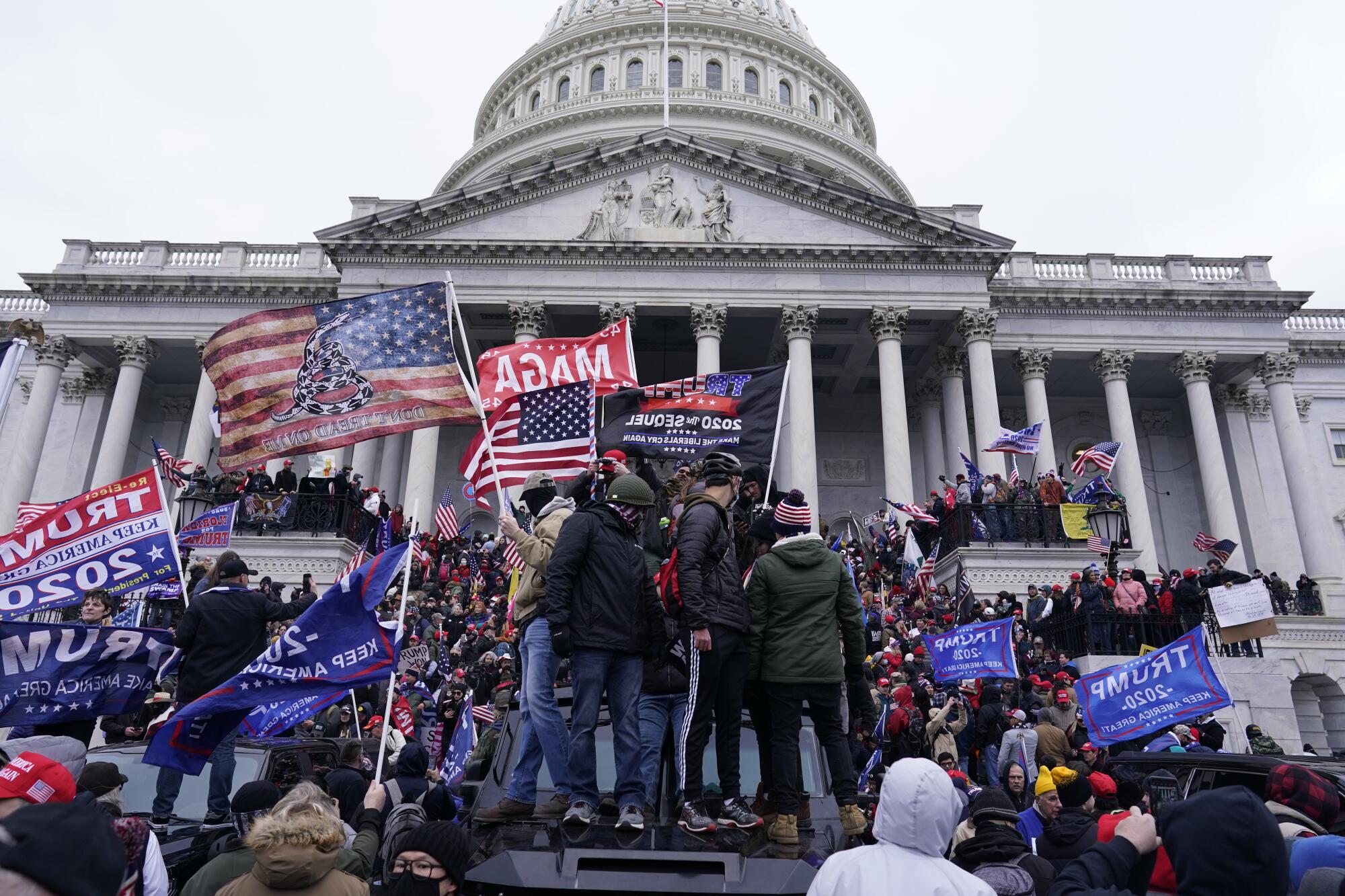 Mob breaches security barrier outside the U.S. Capitol. 