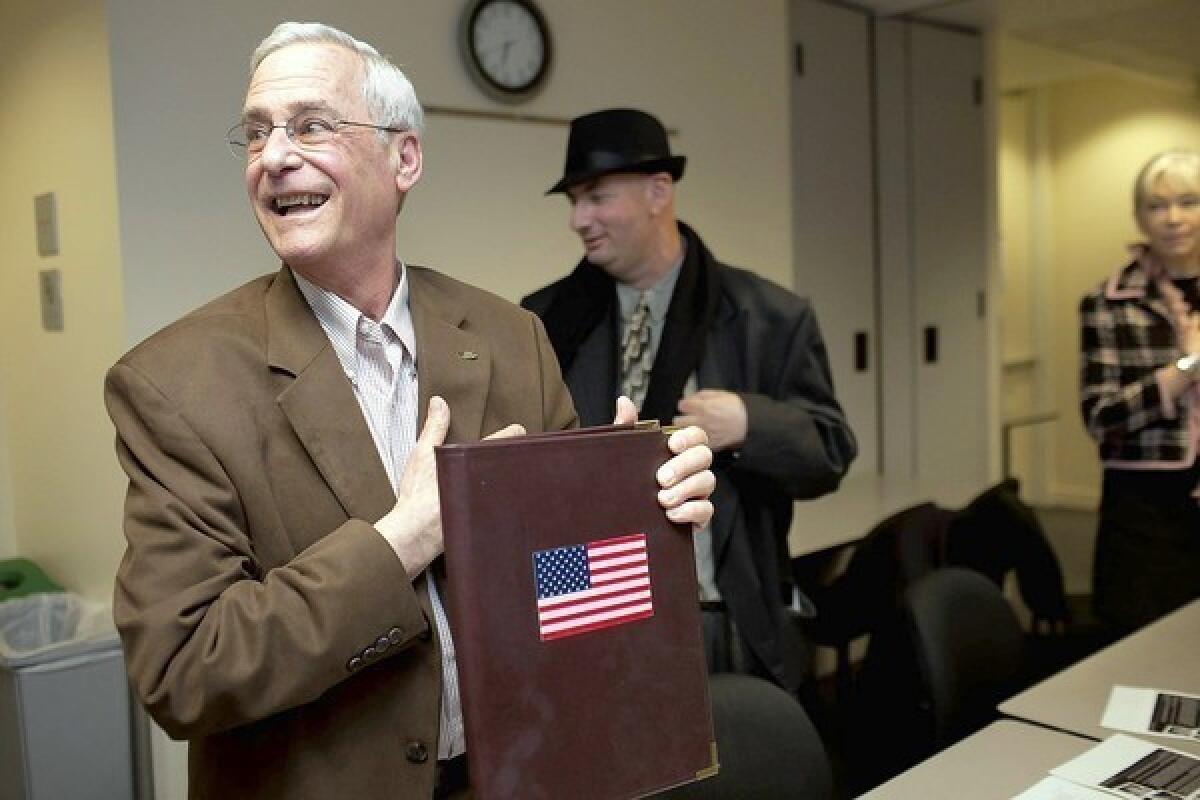 Howard Epstein, vice chairman of communications for the San Francisco Republican Party, holds up his binder with an American flag for the Pledge of Allegiance as a party meeting gets underway at Milton Marks Conference Center in the city.