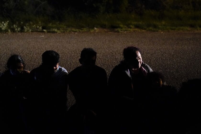 En esta imagen de archivo, tomada el 17 de mayo de 2021, un grupo de migrantes, en su mayoría de Honduras y Nicaragua, esperan en una carretera tras entregarse a las autoridades luego de cruzar la frontera entre México y Estados Unidos, en La Joya, Texas. (AP Foto/Gregory Bull, archivo)