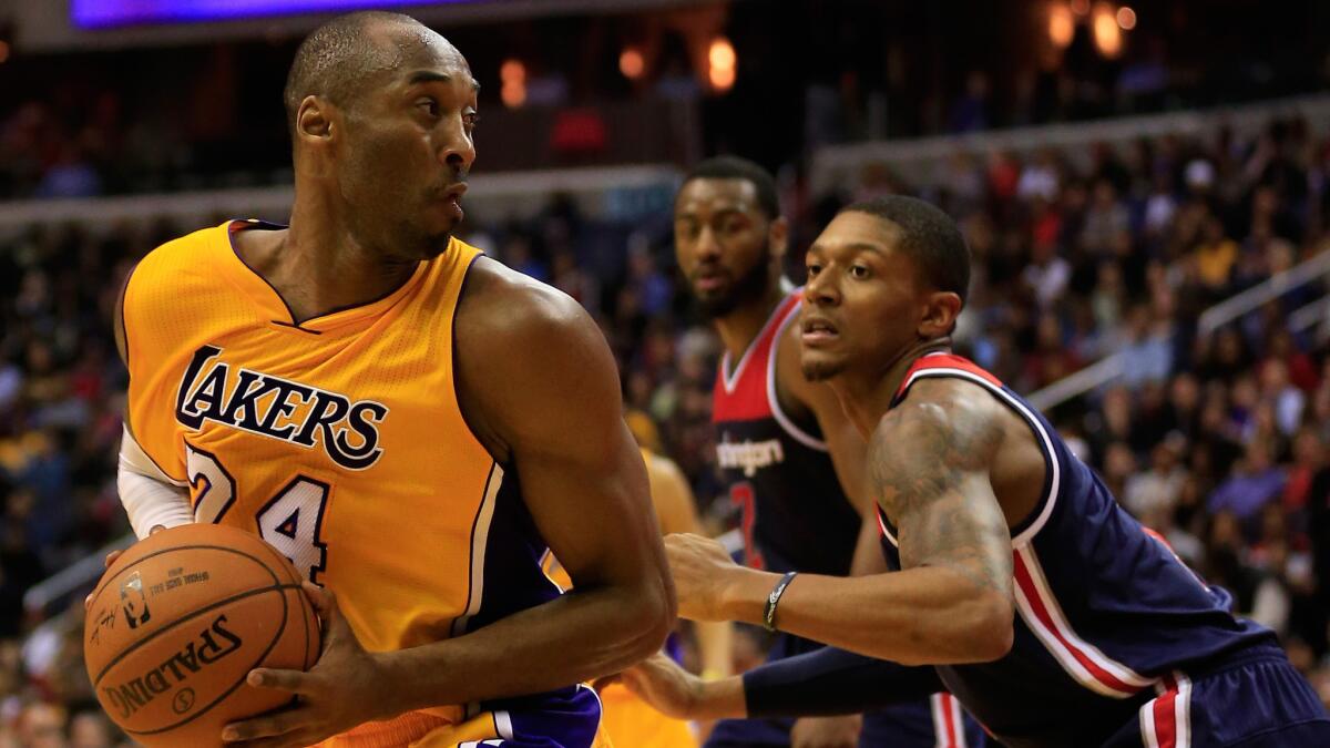 Lakers star Kobe Bryant, left, tries to drive inside on Washington Wizards guard Bradley Beal during the first half of Wednesday's game.
