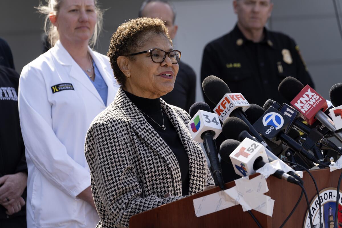 Flanked by medical staff and fire department personnel, Los Angeles Mayor Karen Bass talks during a news conference.