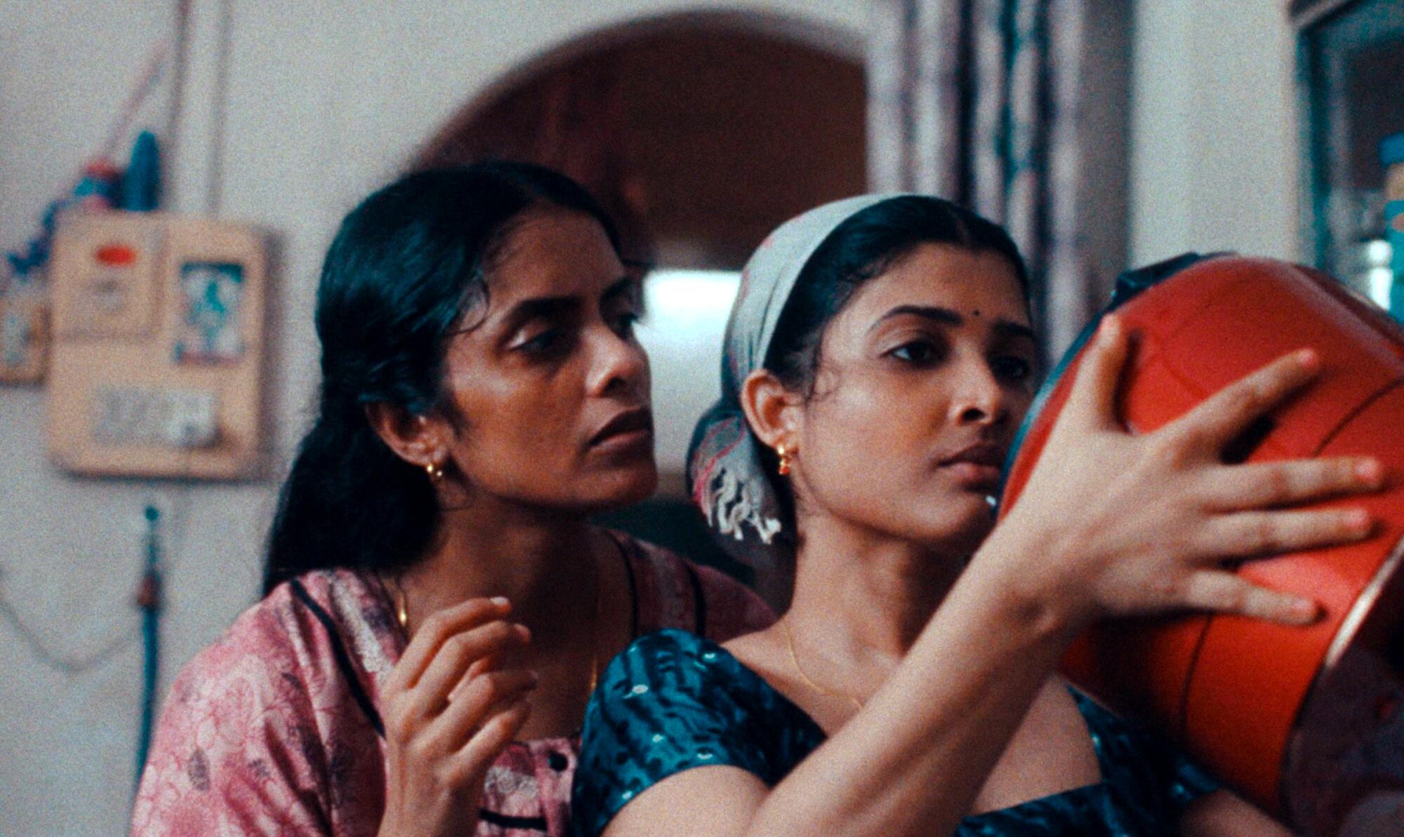 Two women stand in a kitchen.