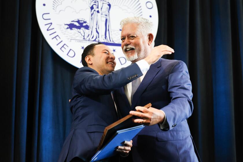 San Diego, CA - January 18: Rafael Castellanos, 2023 chairman, Board of Port Commissioners - San Diego appointee, and Frank Urtasun, 2024 chairman, Board of Port Commissioners - Coronado appointee, hug during the Port of San Diego's swearing in ceremony for its 2024 executive officers for the Board of Port Commissioners at Port Pavilion on Thursday, Jan. 18, 2024 in San Diego, CA. (Meg McLaughlin / The San Diego Union-Tribune)
