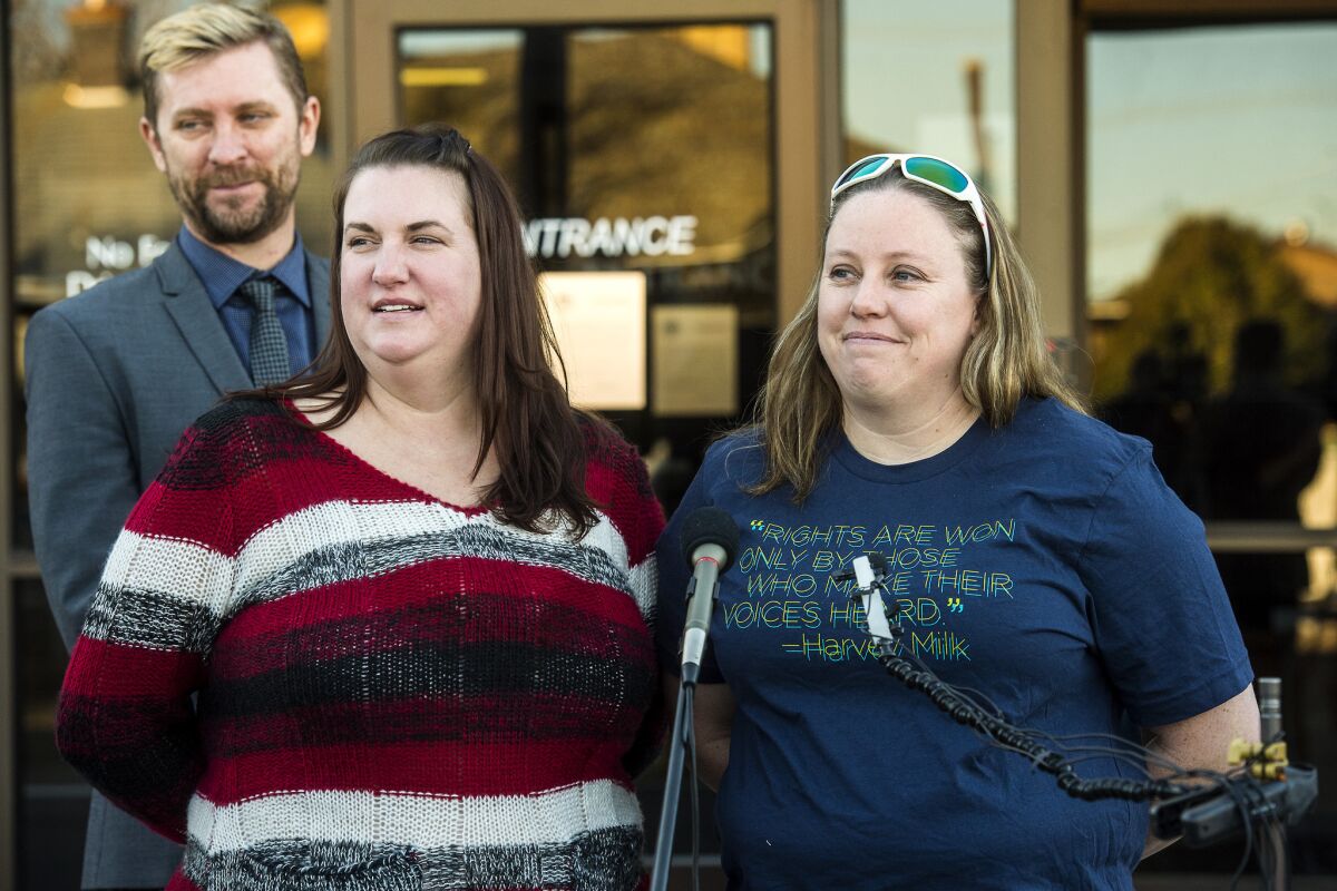 April Hoagland, center, and Beckie Peirce smile during a press conference in Price, Utah on Nov. 13. The married couple announced that they will be able to keep a baby girl they have been raising as foster parents.