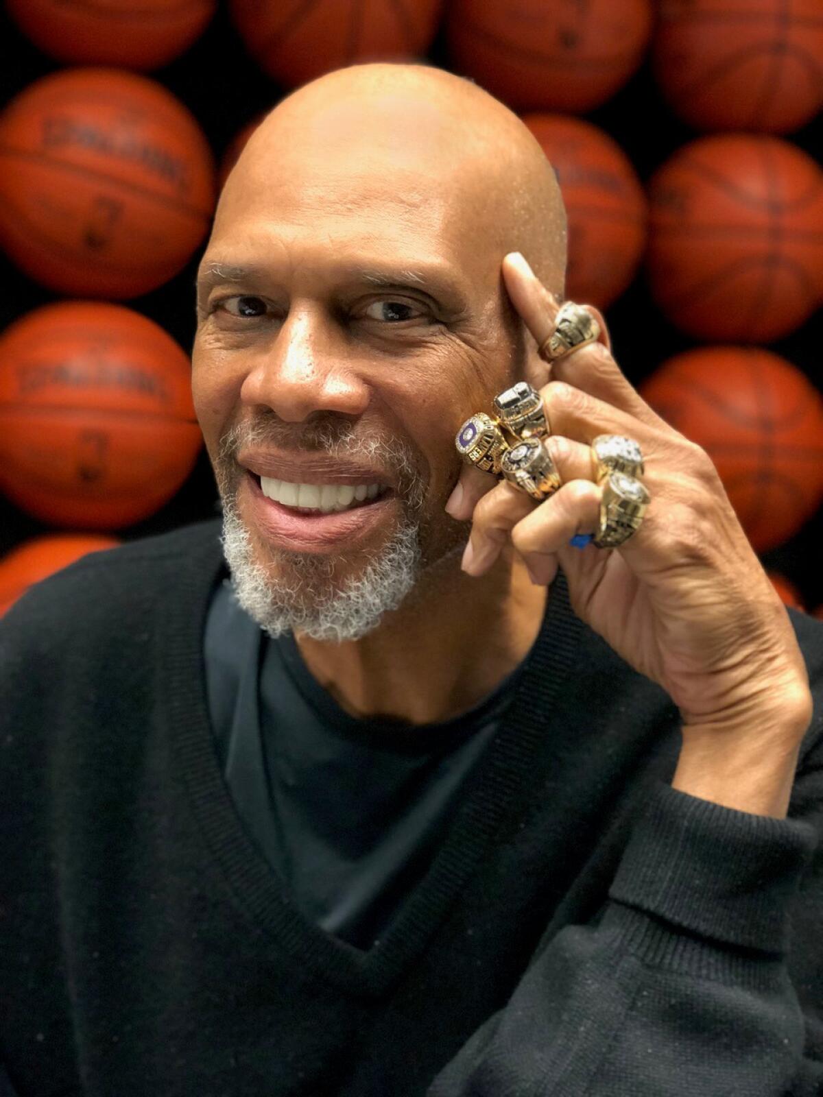 Lakers star Kareem Abdul-Jabbar poses with his championship rings.