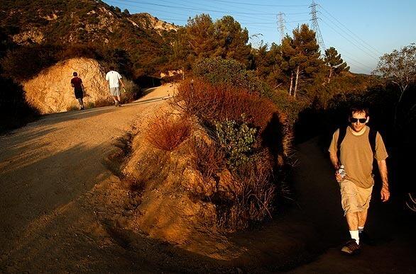 Saro Chakarian follows his friends Paul Spiering, left, and Mike Shen on a hike up the Mt. Wilson Toll Road. The trail was closed by landslides in 2004, but after six months of construction it's just days away from its official reopening.