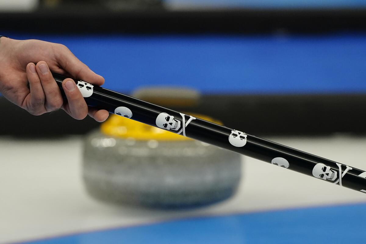Christopher Plys of the United States holds a broom during a men's curling match against Sweden.