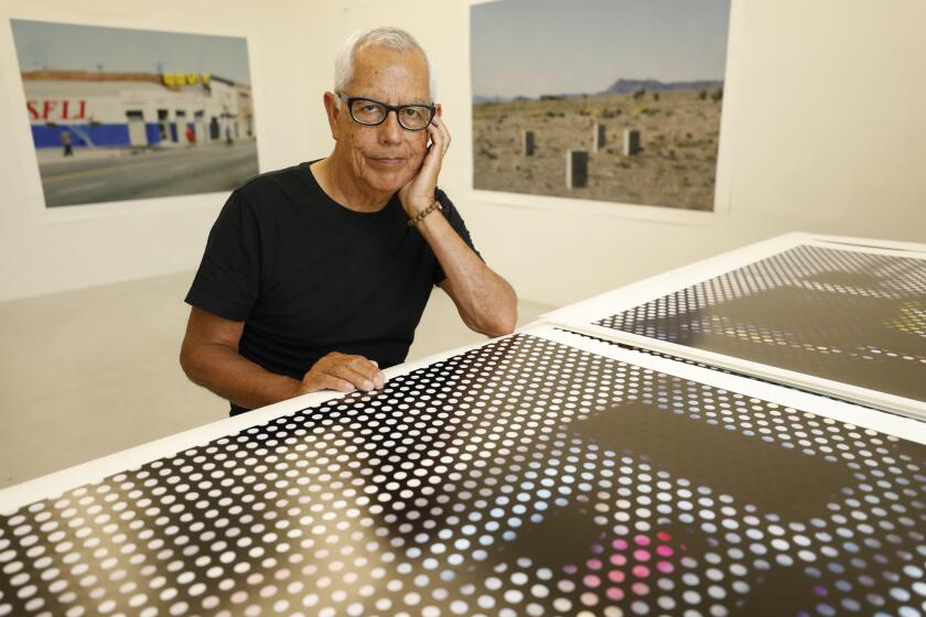 LOS ANGELES, CA - JULY 19, 2019 - Photographer Anthony Hernandez who has been photographing since the 1970s, has become renowned for his incisive photos of SoCal urbanscapes is photographed in his Crenshaw area studio, where he is testing out large prints of his latest images on July 19, 2019. A native of Los Angeles who was raised in Boyle Heights, Hernandez has been the subject of a retrospective at SFMOMA. And this year his work has gone on view at the Venice Biennale in Italy and the Nelson Atkins Museum of Art in Kansas City. But his work less seen in Los Angeles, where museums have largely overlooked his photography. However, a show at Kayne Griffin Corcoran offers a rare opportunity to see his work in L.A. (Al Seib / Los Angeles Times)