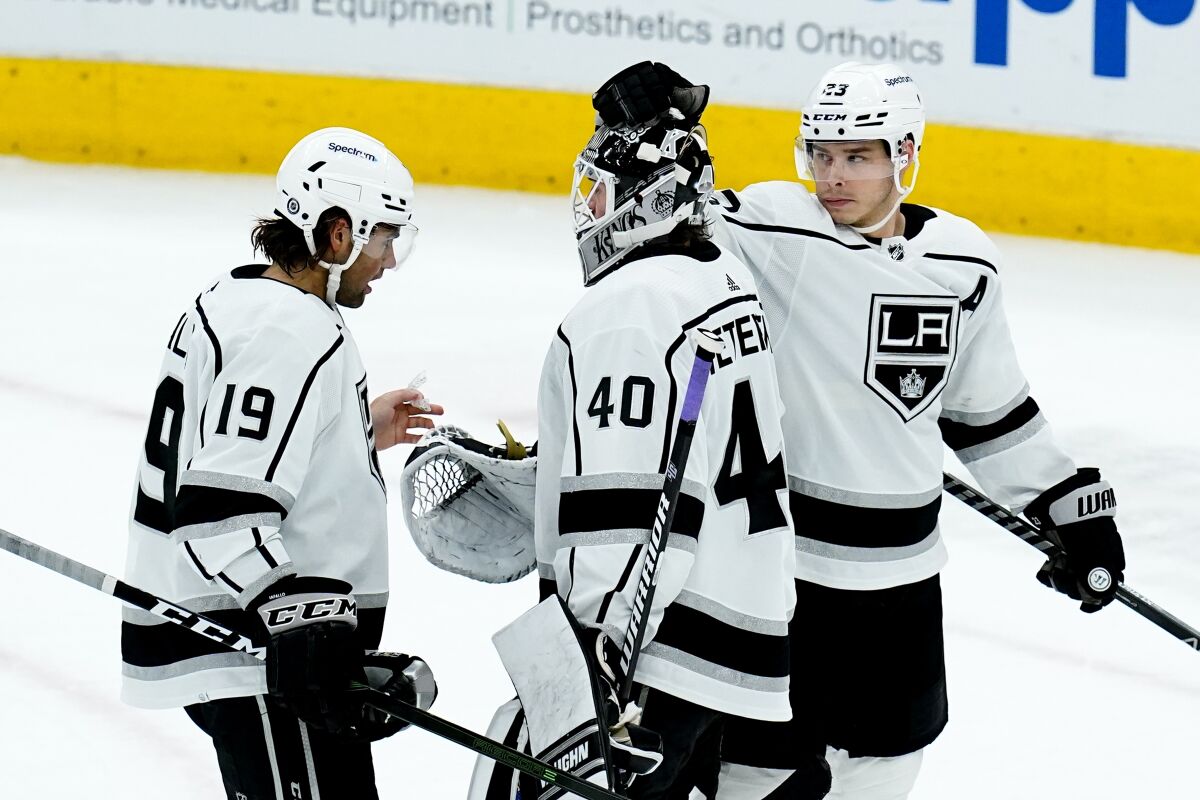 Kings goaltender Cal Petersen celebrates a win over the Arizona Coyotes with Alex Iafallo (19) and Dustin Brown on Feb. 23. 