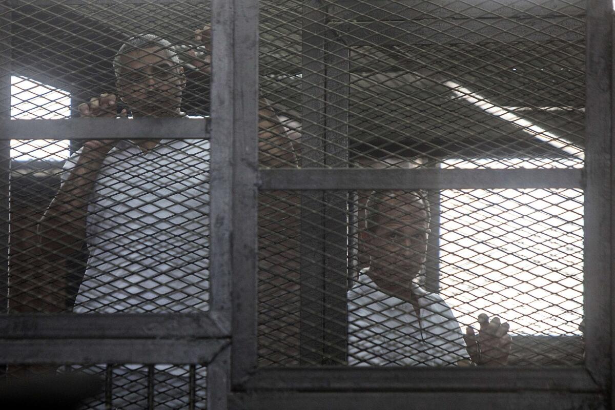 Australian journalist Peter Greste, right, and another defendant appear in a Cairo courtroom during a March 22 proceeding in their trial on charges of supporting the Muslim Brotherhood.