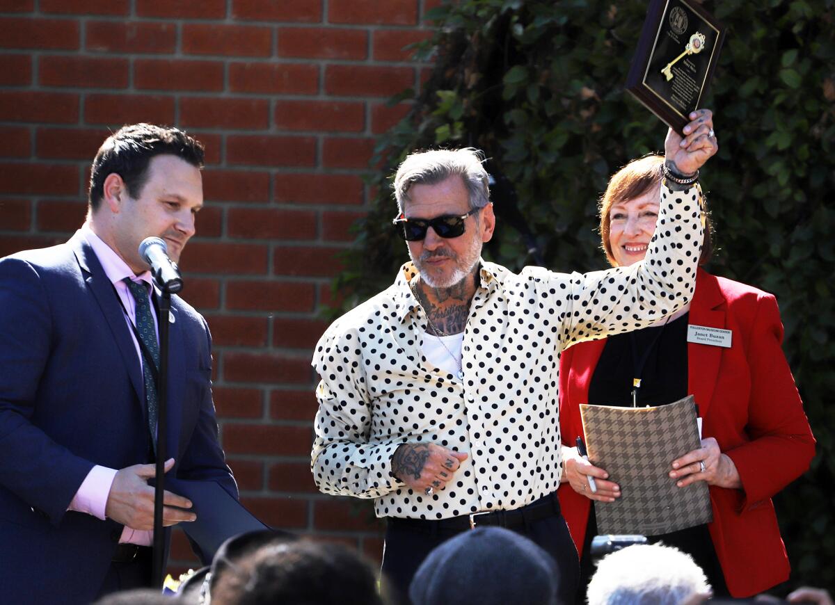 Mike Ness, frontman for punk rock band Social Distortion, holds up the key to the city of Fullerton.