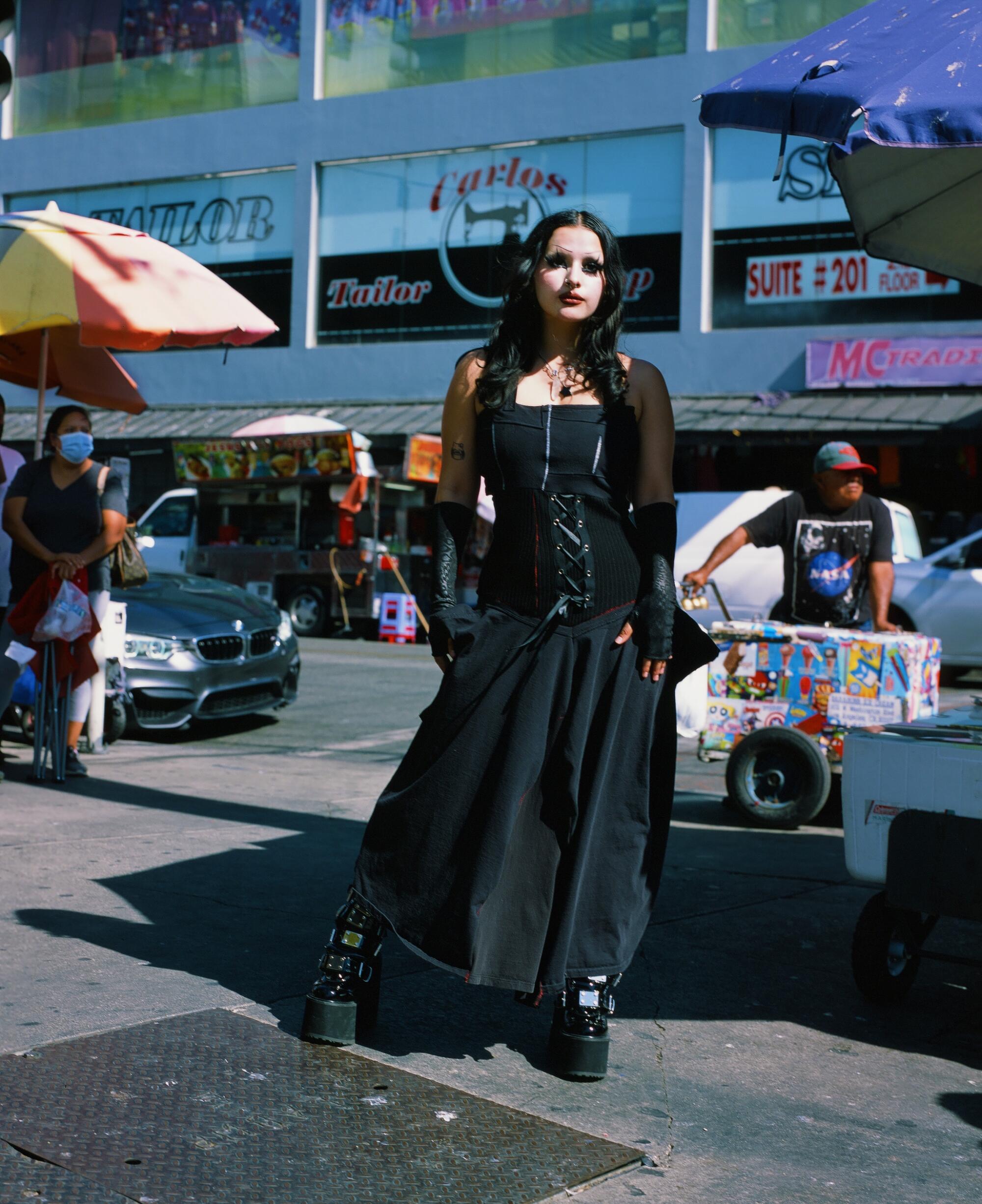 Photo of well-dressed person standing on the sidewalk.