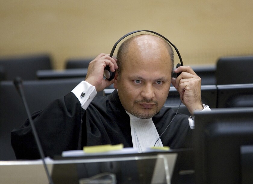 FILE - In this Monday, June 4, 2007 file photo, lawyer Karim Khan adjust his headphones in the courtroom of the Special Court for Sierra Leone in The Hague, the Netherlands. Khan is being sworn in Wednesday, June 16, 2021 as the new chief prosecutor of the International Criminal Court, taking leadership of a busy and financially stretched team that is probing alleged atrocities around the globe. Khan, a 51-year-old English lawyer, has years of experience in international lawyer as a prosecutor, investigator and defense attorney. He takes over from Fatou Bensouda of Gambia, whose nine-year term ended Tuesday. (AP Photo/Robert Vos, Pool, File)