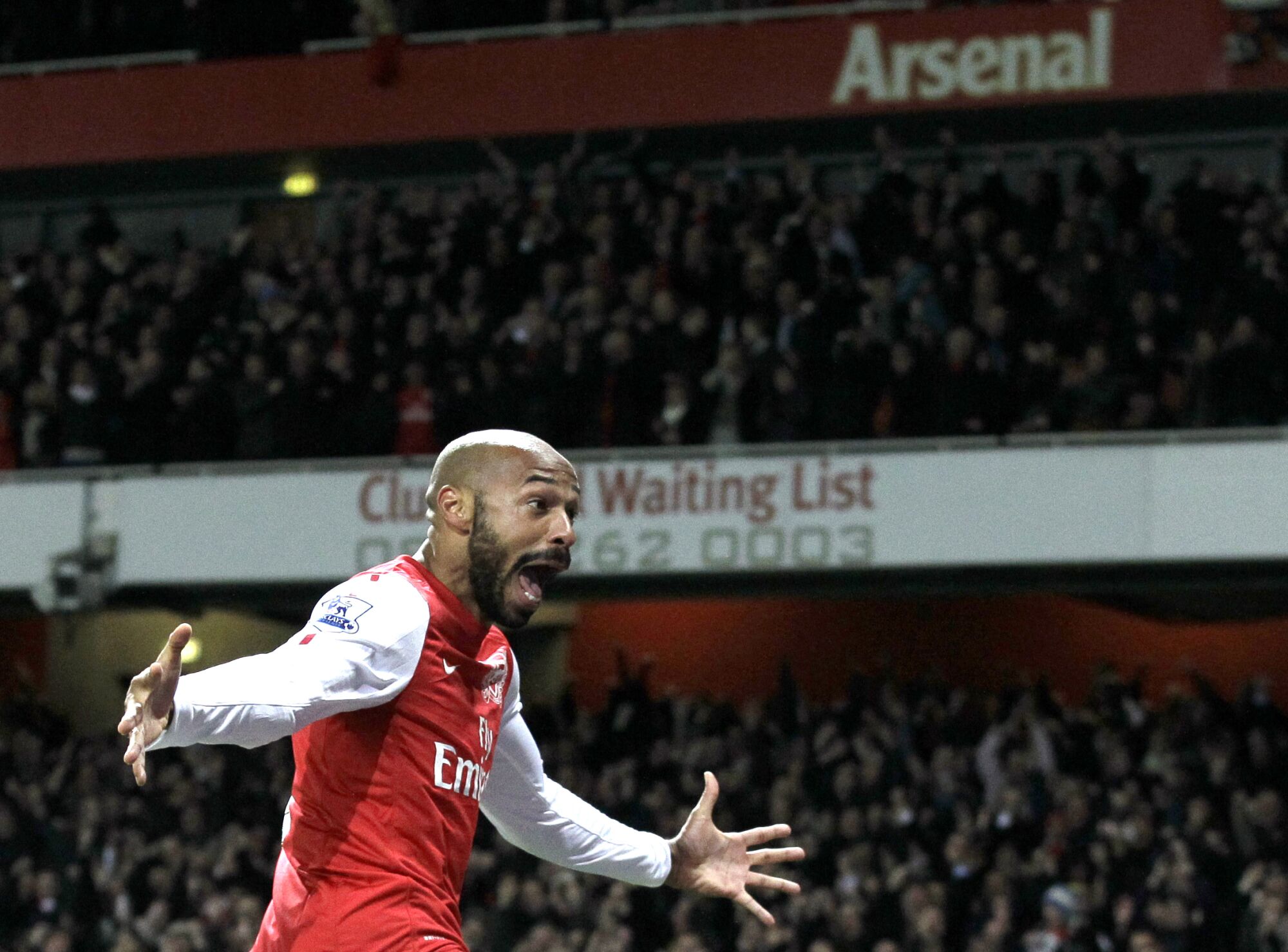 Thierry Henry extends his arms and shouts, celebrating scoring for Arsenal in 2012