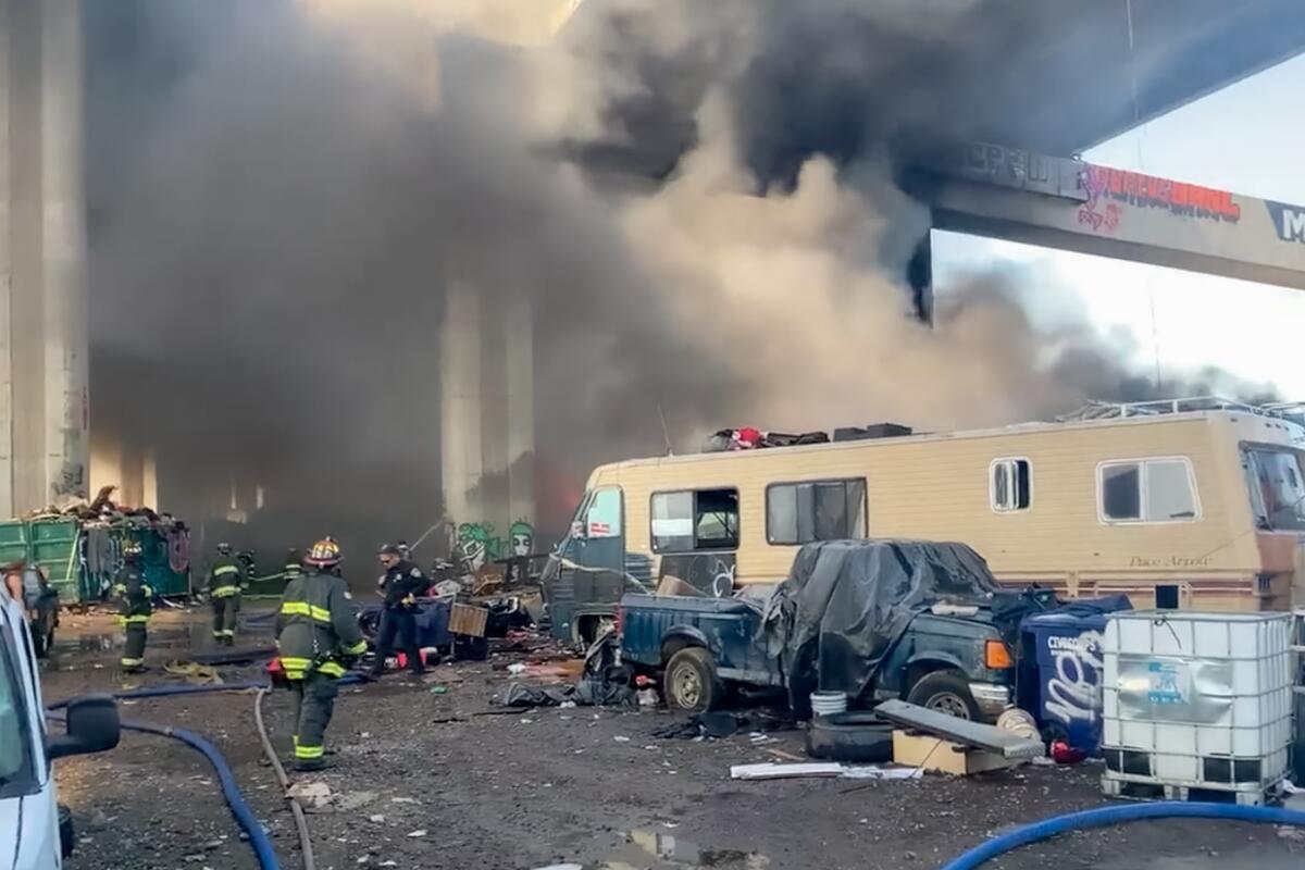 Firefighters are on the scene after several vehicles caught fire at a homeless encampment.