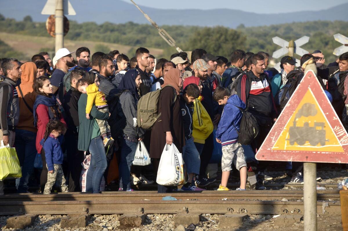 Migrants and refugees wait to cross the line at the Greek-Macedonian border near the village of Idomeni, in northern Greece on September 13, 2015.