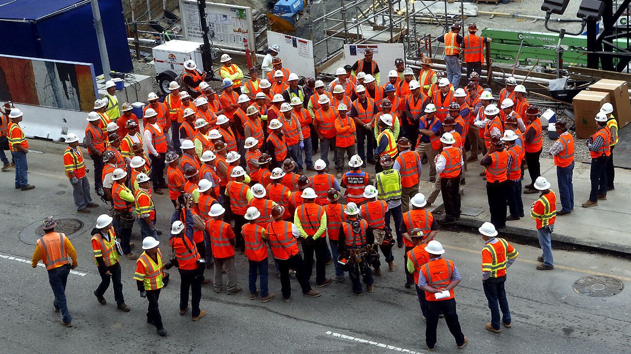 Workers gather on Figueroa Street before the record-setting concrete pour for the foundation of the 73-story, 1,100-foot-tall New Wilshire Grand tower, which will be the tallest structure west of the Mississippi River upon its completion.