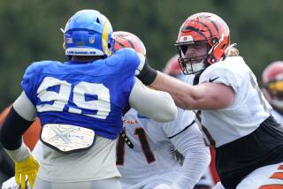 Cincinnati Bengals guard Alex Cappa, right, and offensive tackle La'el Collins (71) block Los Angeles Rams defensive tackle Aaron Donald (99) during a drill at the team's NFL football training facility, Wednesday, Aug. 24, 2022, in Cincinnati. (AP Photo/Jeff Dean)