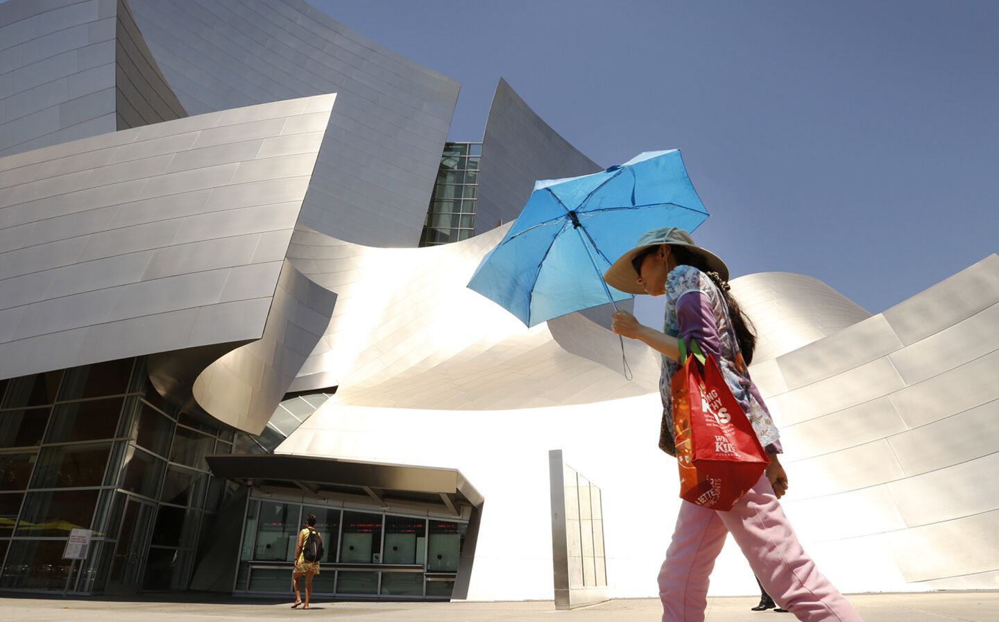 Stephanie Wong creates her own shade with an umbrella walking past Disney Hall in downtown Los Angeles on Monday.