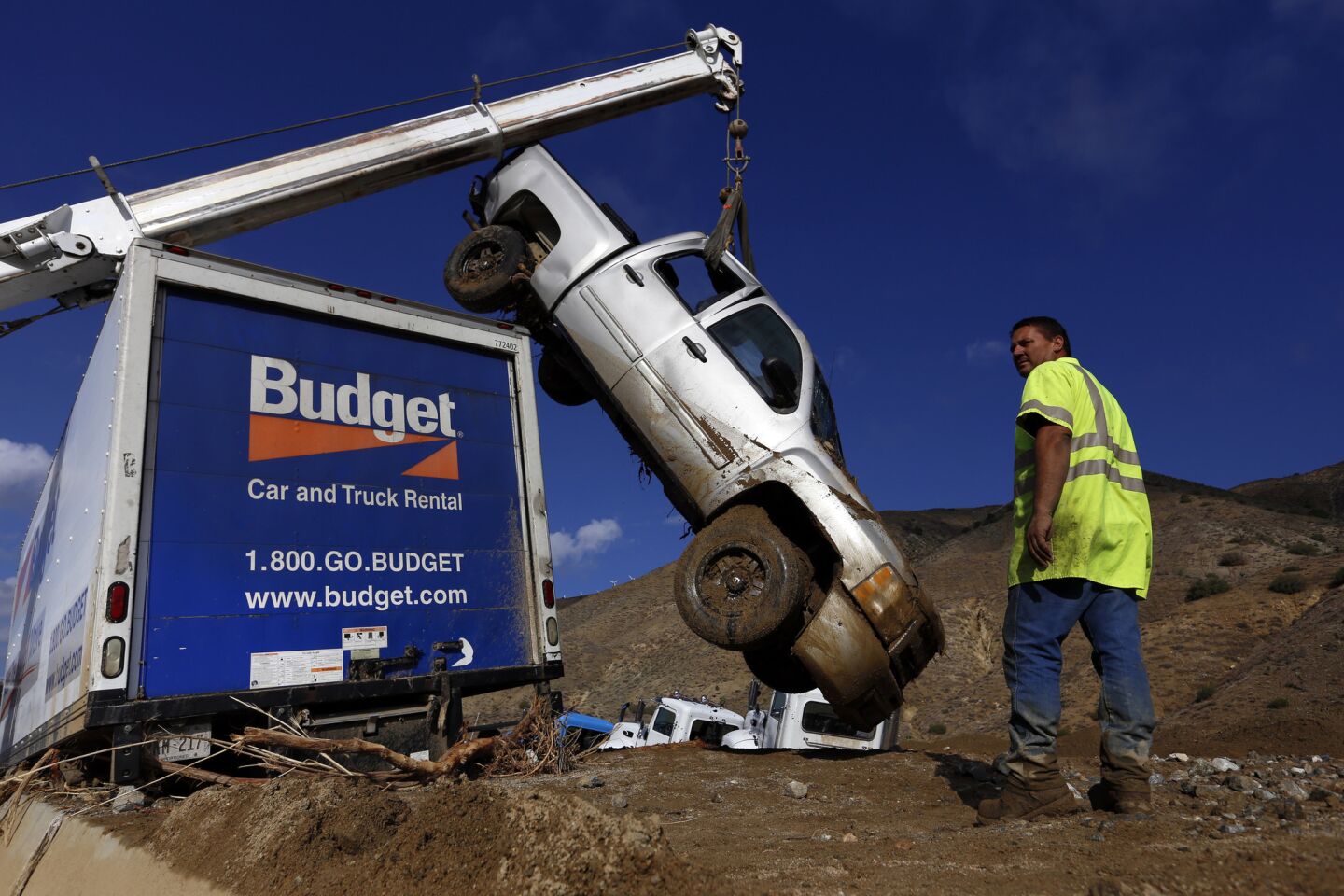 Bill Beaury of Golden Empire Towing supervises the removal of vehicles encased in mud on California 58 east of Tehachapi on Saturday, Oct. 17, 2015. Caltrans is moving mud and debris so that the vehicles can be removed.