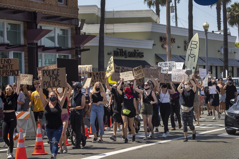 Hundreds protest racism and police brutality in a march along Balboa Boulevard in Newport Beach on Wednesday.
