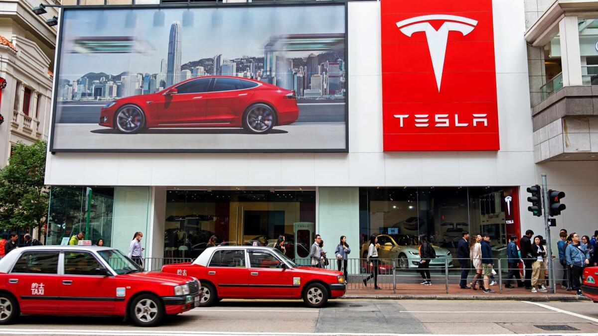 A white sedan bearing Tesla’s logo was captured on video catching fire on Sunday.