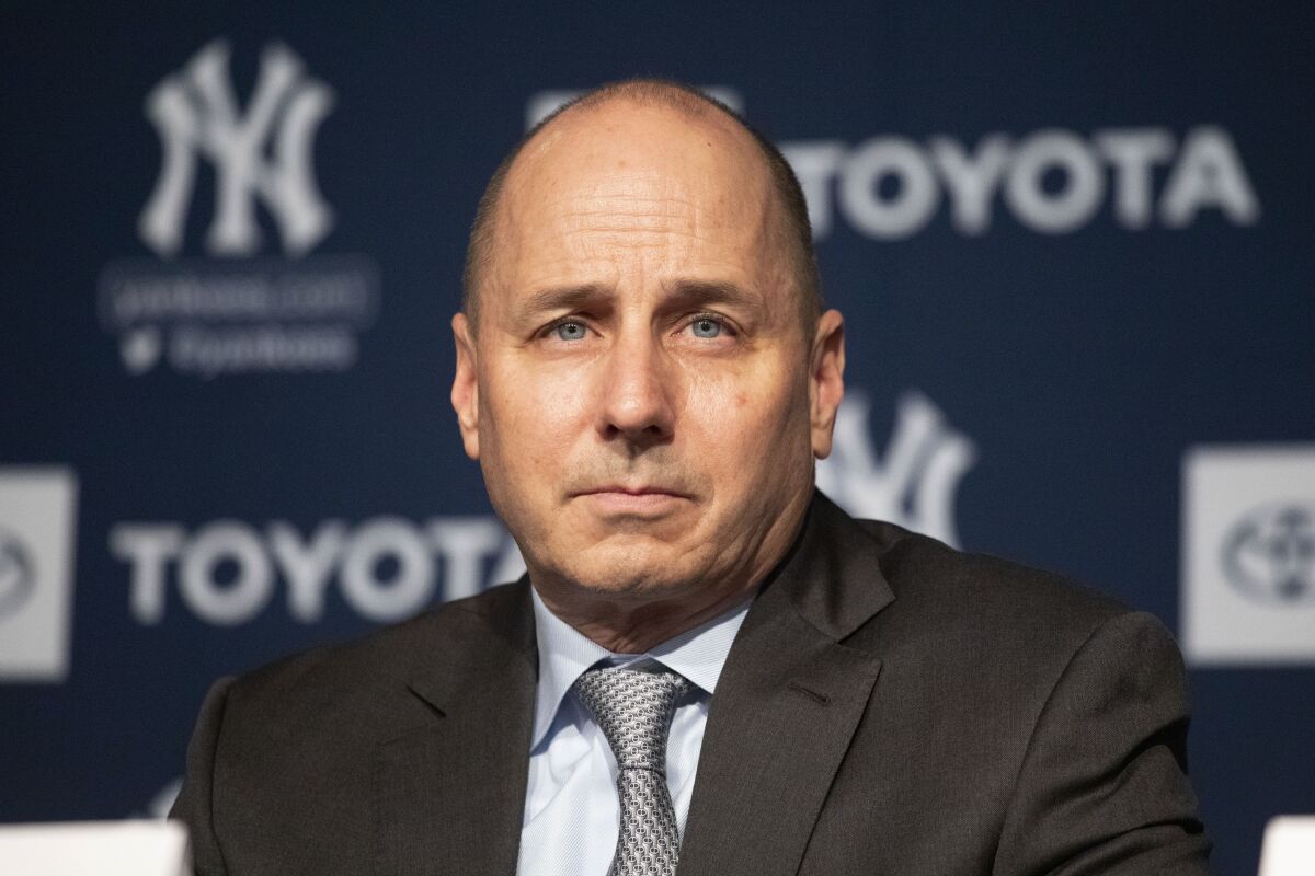 FILE -Yankees general manager Brian Cashman listens as Gerrit Cole is introduced as the newest New York Yankees player during a baseball media availability, Wednesday, Dec. 18, 2019 in New York. The New York Yankees were fined $100,000 by baseball Commissioner Rob Manfred for using their dugout phone to relay information about opposing teams’ signs during the 2015 season and part of 2016. The fine was disclosed in a Sept. 14, 2017, letter from Manfred to Yankees general manager Brian Cashman that is set to be unsealed in U.S. District Court in New York this week as part of a dismissed lawsuit by a fan. (AP Photo/Mark Lennihan, File)