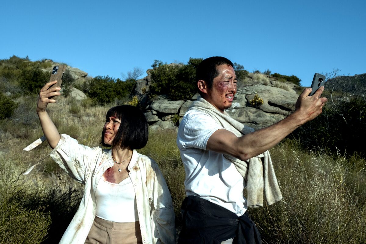 A ragged-looking woman (Ali Wong) and man (Steven Yeun) search for cell-phone service in the wilderness in "Beef."