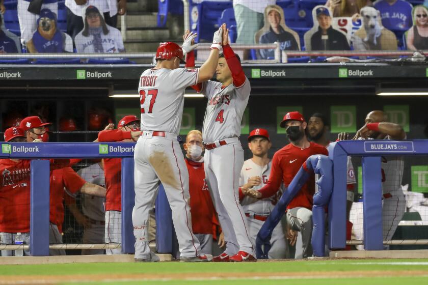 Los Angeles Angels' Jose Iglesias (4) congratulates Mike Trout after his solo home run against the Toronto Blue Jays during the fifth inning of a baseball game Thursday, April 8, 2021, in Dunedin, Fla. (AP Photo/Mike Carlson)