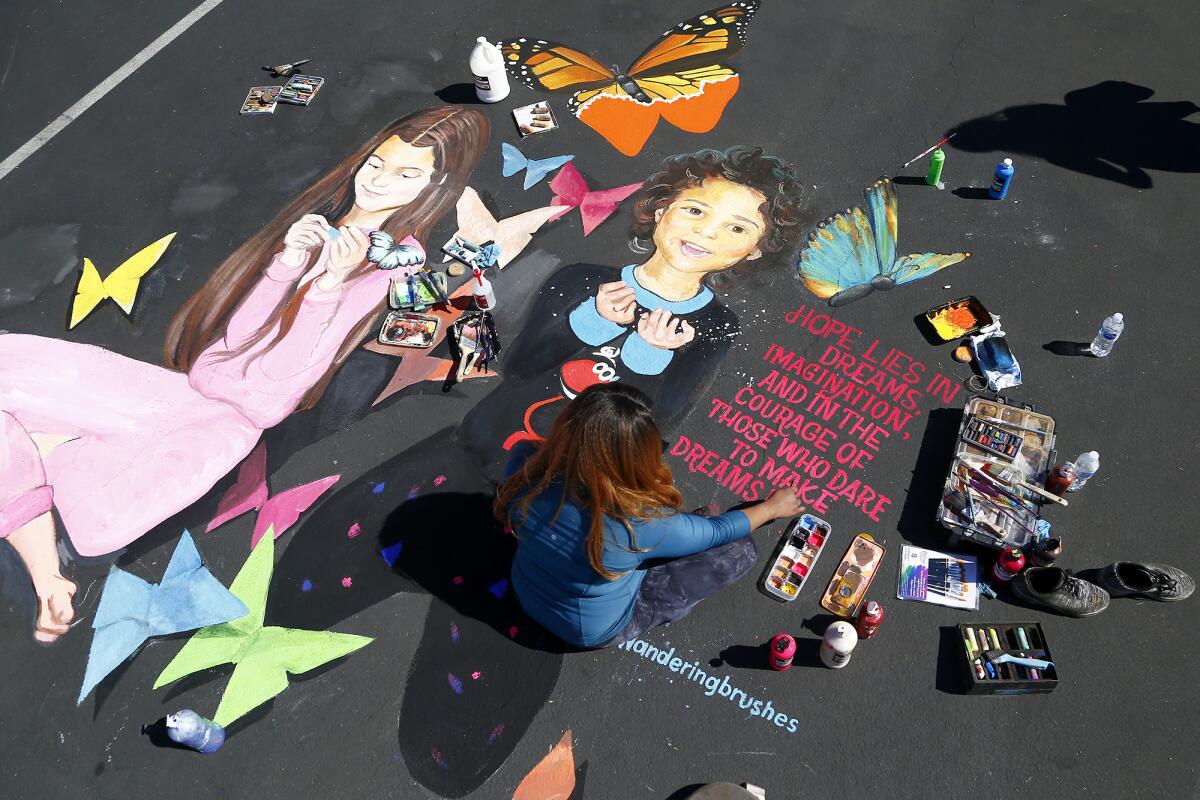 Artist Amanda Lee Gibbs works on a portrait of her nieces in a parking lot by Disneyland.