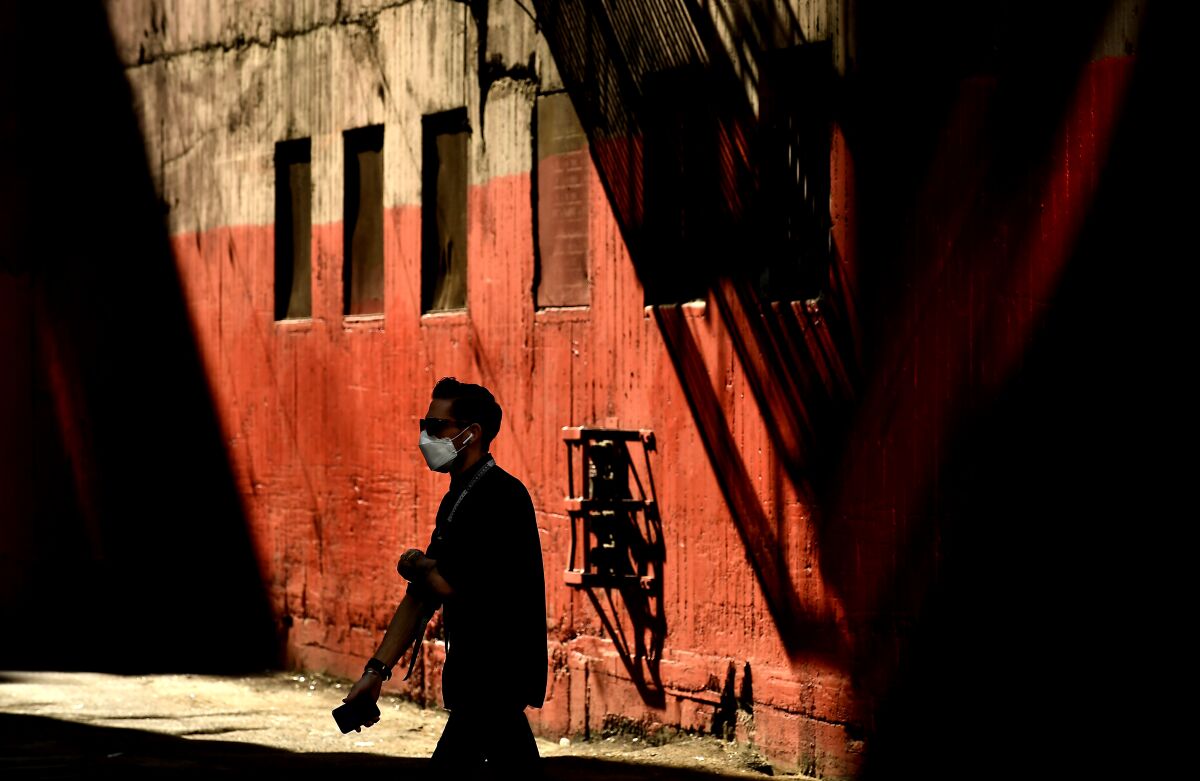 A man in a mask walks in downtown L.A.