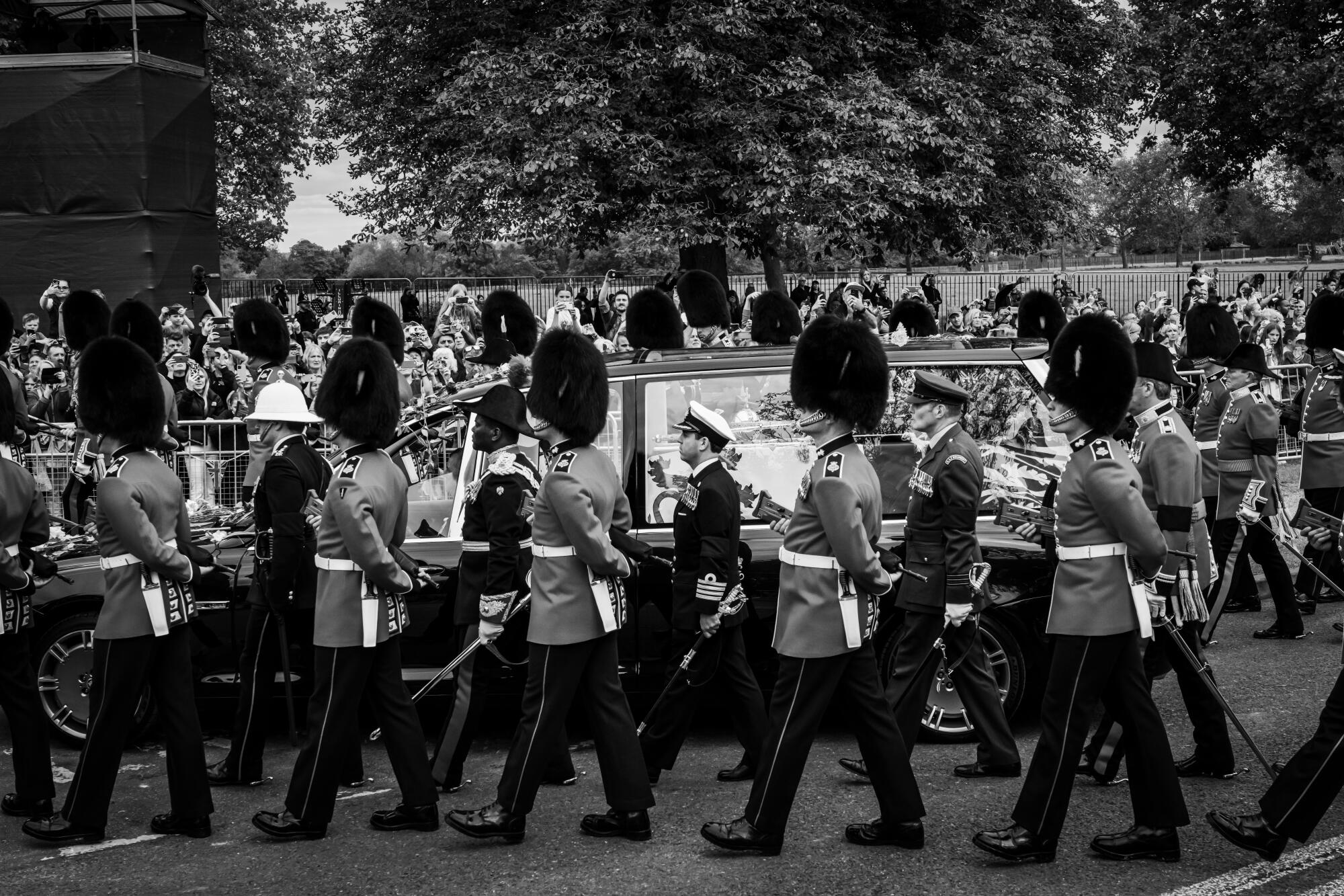 A funeral procession bearing the coffin of Queen Elizabeth II makes its way towards the road leading to Windsor Castle.