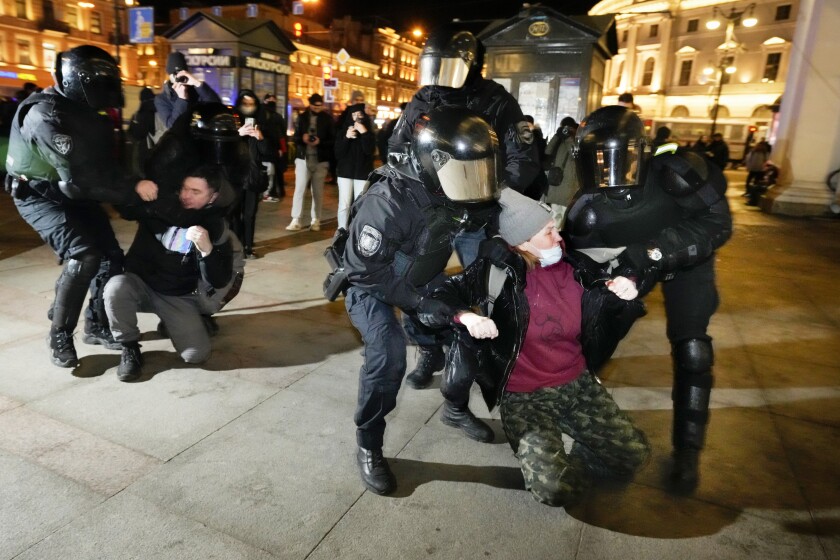 In Moscow, the mood becomes darker as Putin presses Ukraine war - Los Angeles Times 2 A woman, right, and a man are seized by security forces in black uniform and helmets